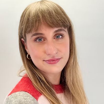 Roisin, a white woman with blonde hair wearing a striped top, looking at the camera and smiling.
